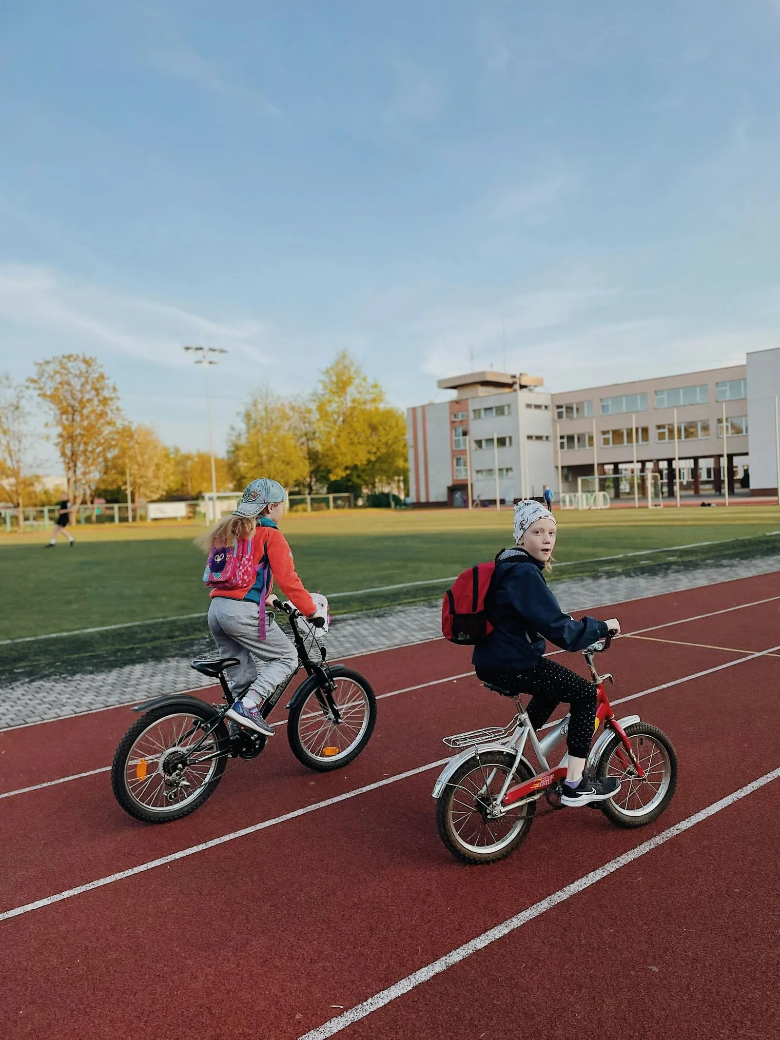 A couple of kids riding bikes on a track.